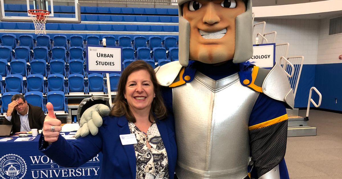 A professor standing with the lancer mascot