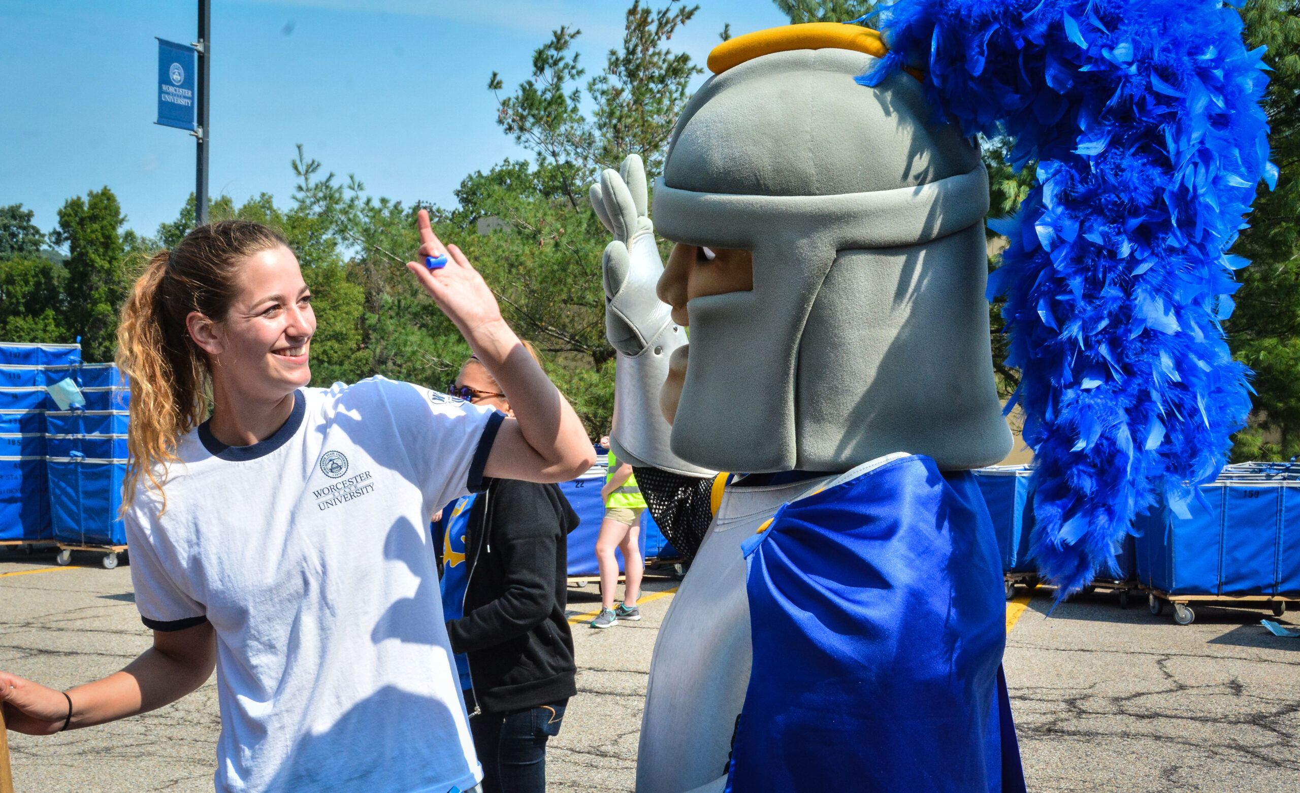 A student high fiving the school mascot, Chandler the lancer