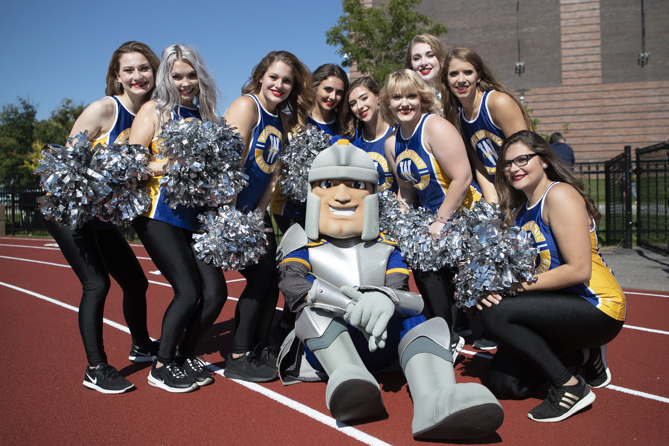 Worcester State cheerleaders posing with the Worcester State Lancer mascot on Homecoming