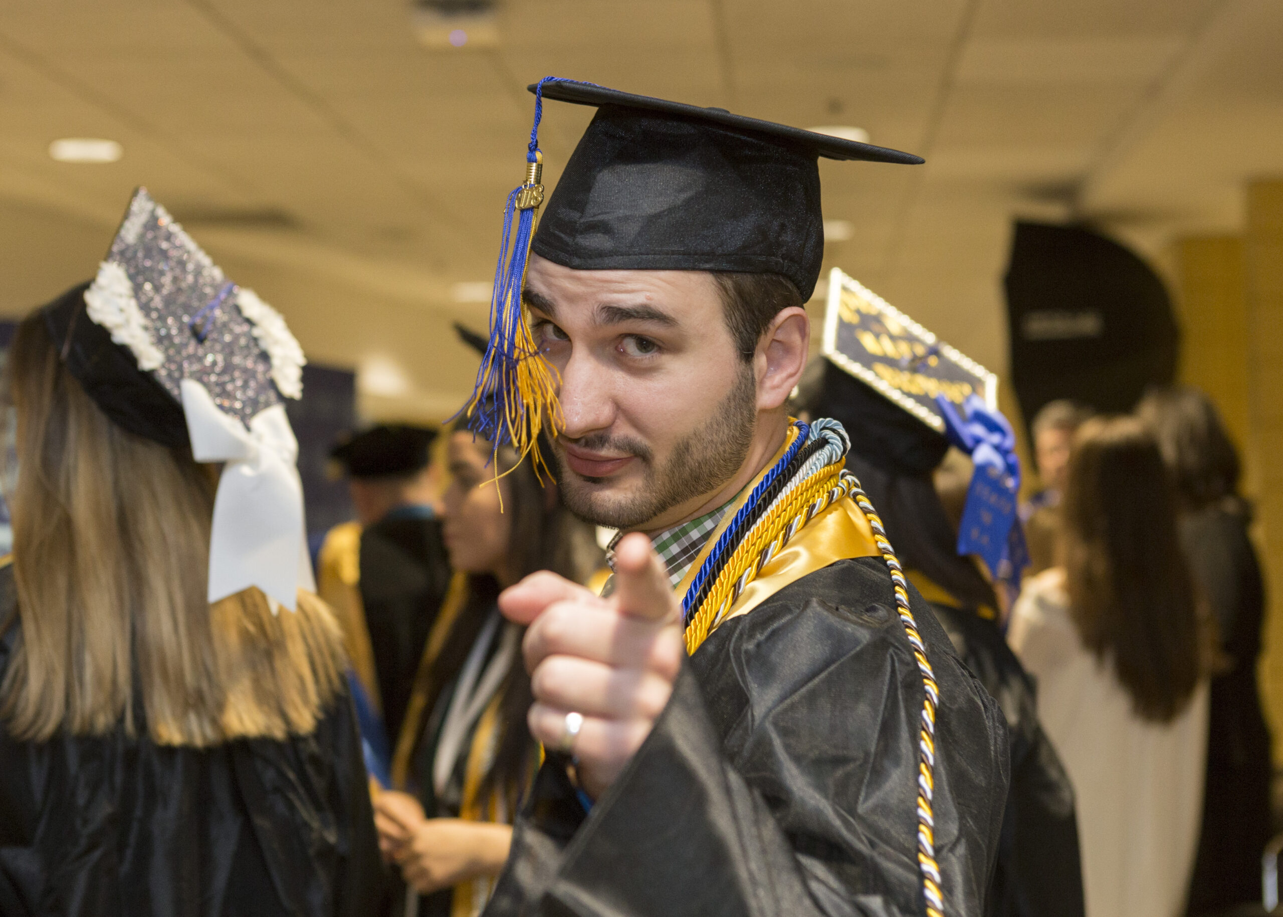 graduating student pointing at camera