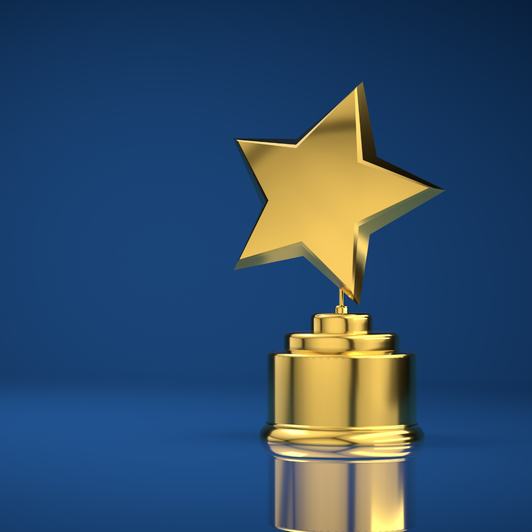 A gold star-shaped trophy on a stepped gold base, displayed against a plain blue background.