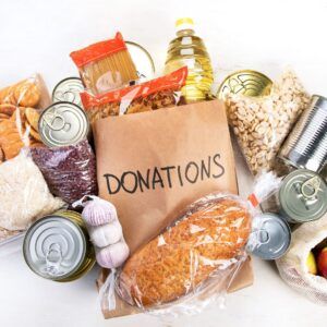 paper bag stating "donations" surrounded by groceries and food items