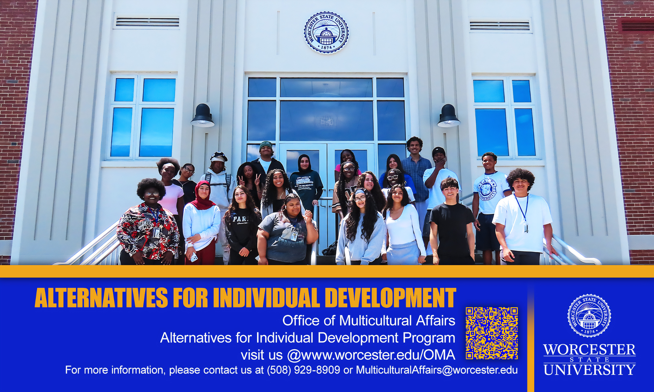 A diverse group of students stands on steps outside a building under a sign reading “ALTERNATIVES FOR INDIVIDUAL DEVELOPMENT” at Worcester State University.