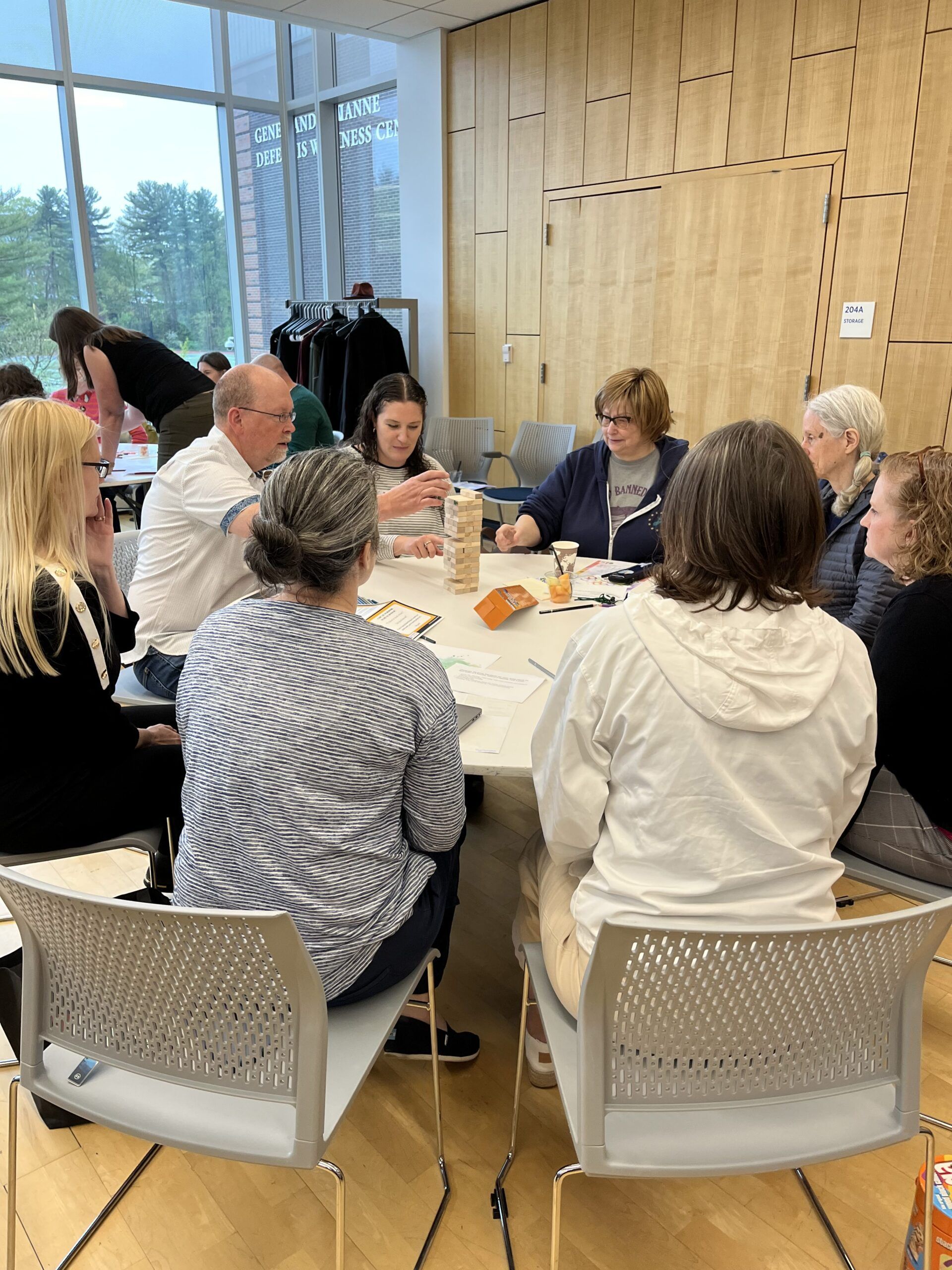 A group of faculty members engaged in a collaborative discussion at a round table during a Center for Teaching and Learning workshop session at Worcester State University.