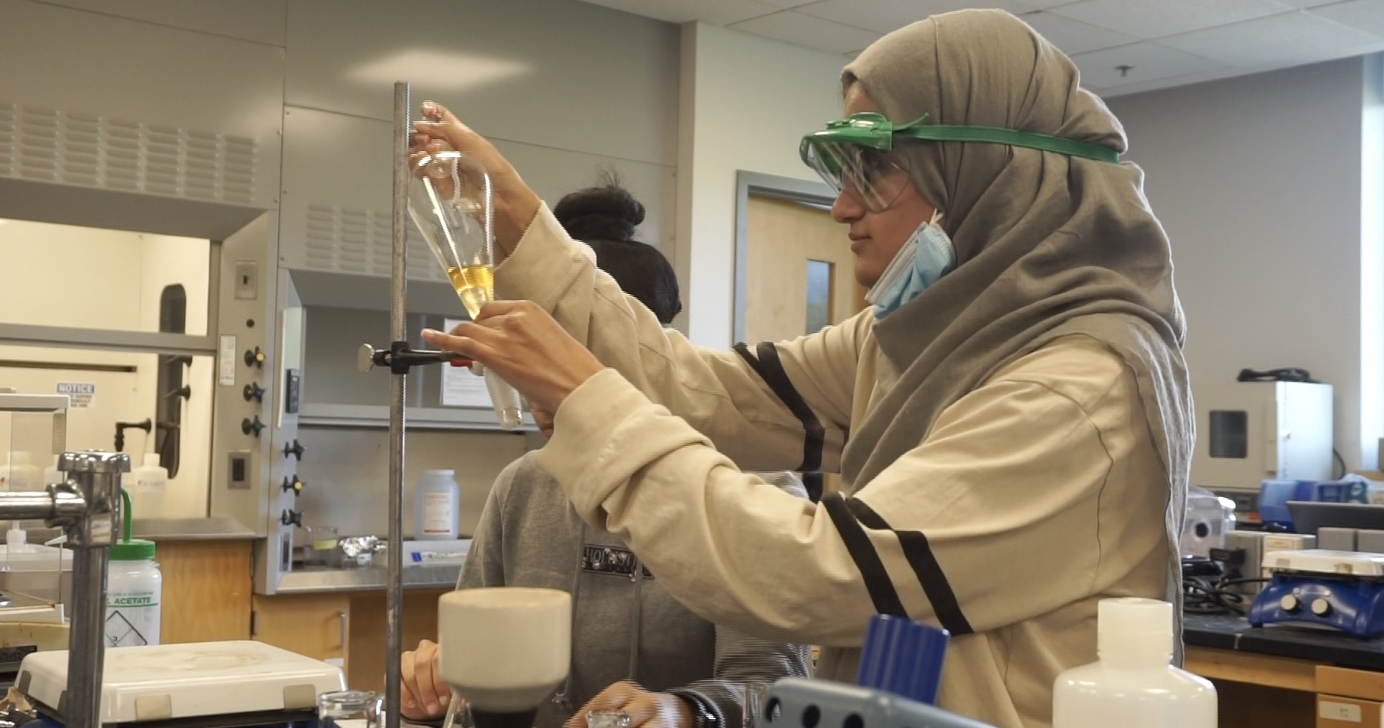 Chemistry student examines tubular beaker