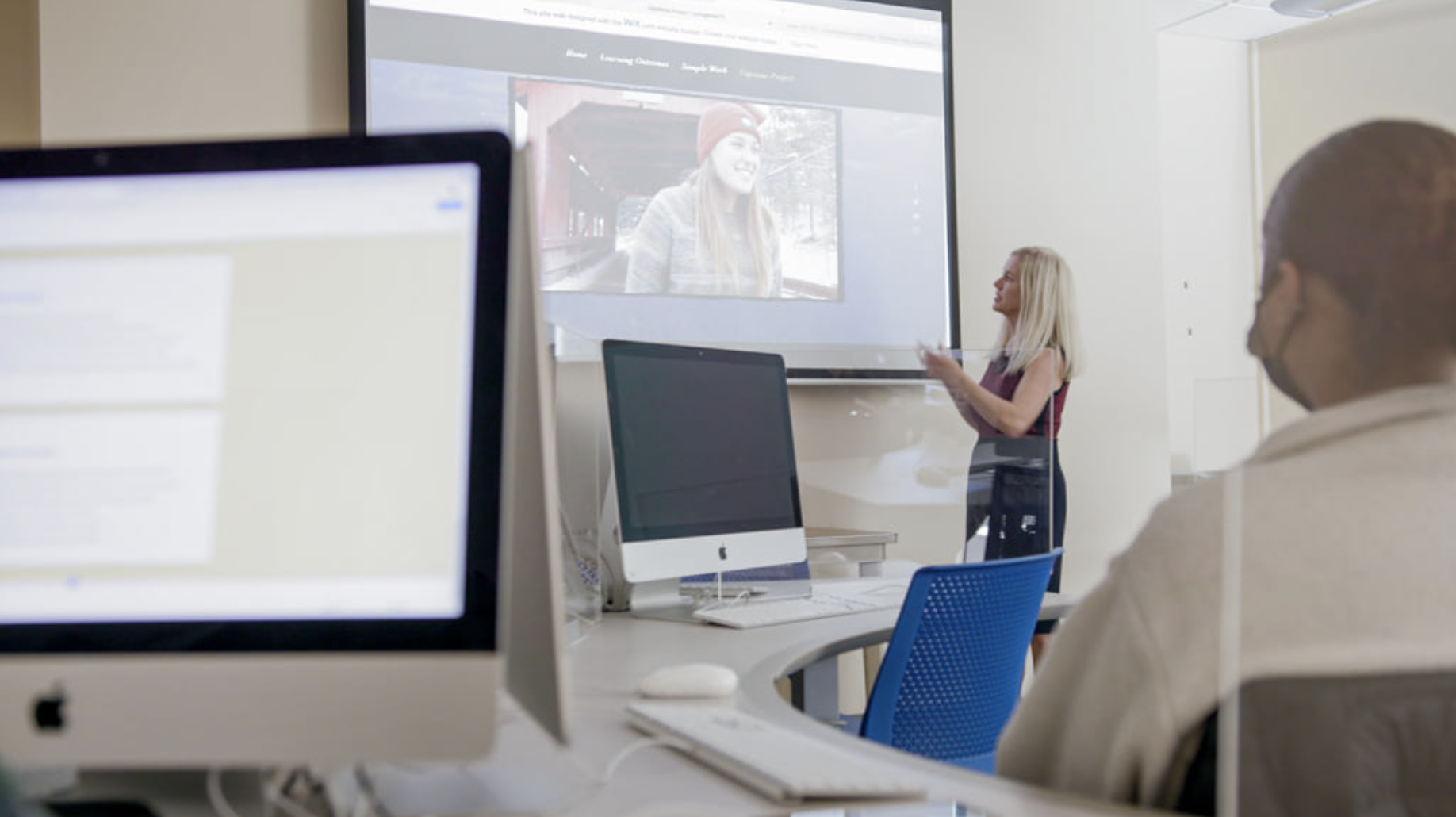 Communication professor at Worcester state shows students a video on projector