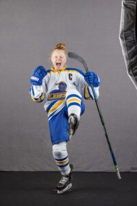 Clare Conway, in her hockey uniform, makes a celebratory gesture.