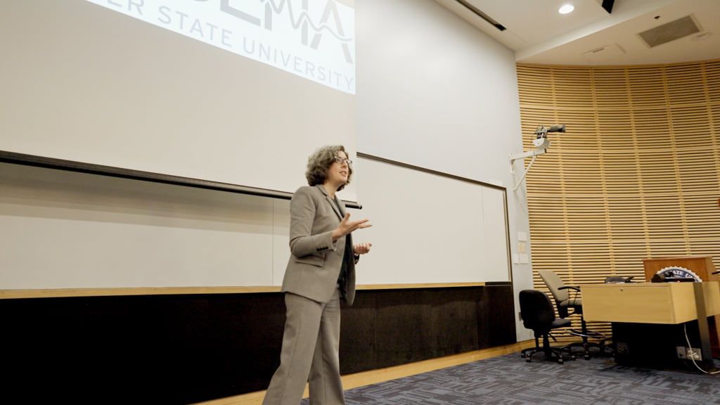 Professor presenting in front of a projection screen