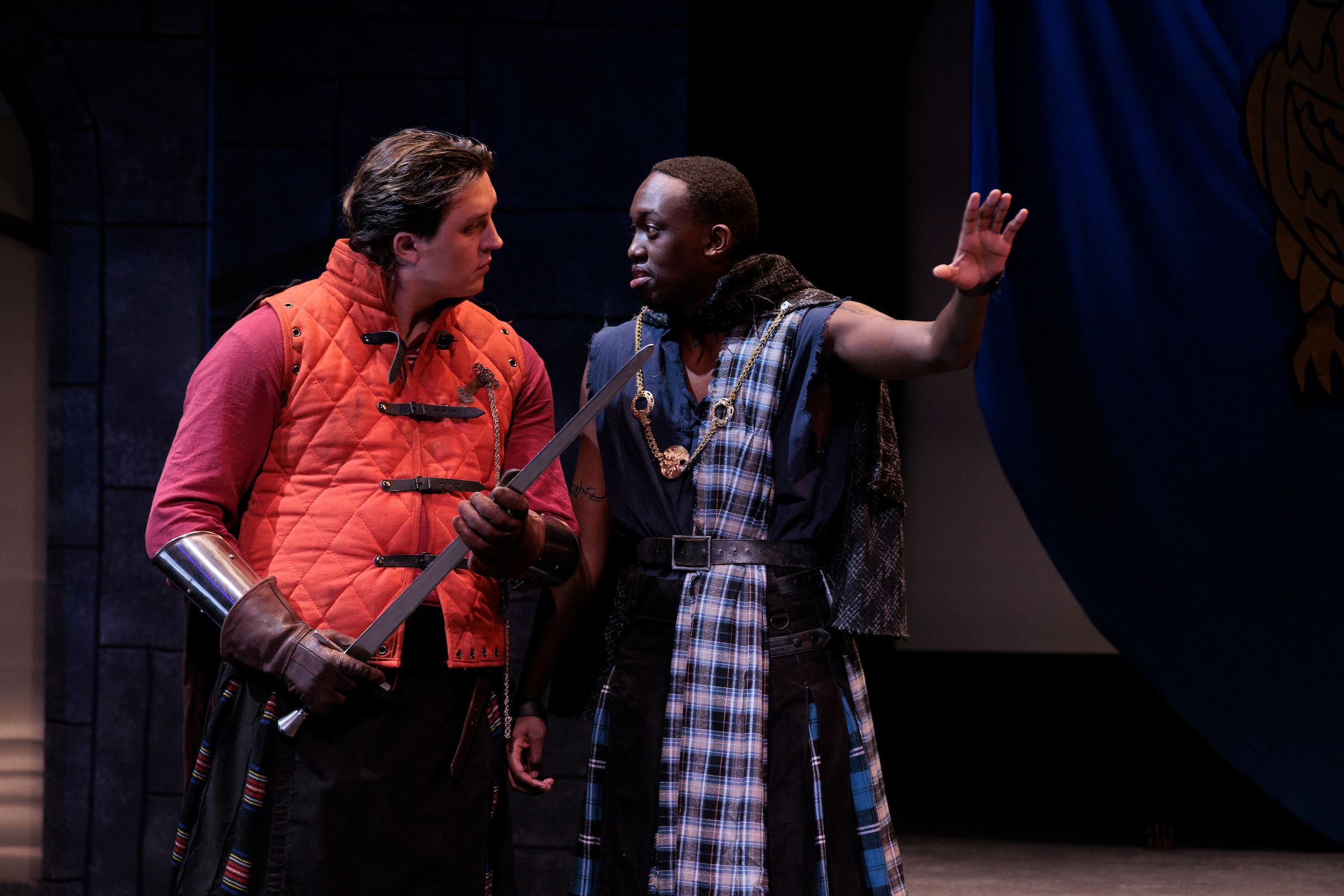 Macbeth (John McAuliffe) converses with Banquo (Jeremy Ndungu).