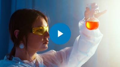 Major Plus Thumbnail - student looking into orange science beaker