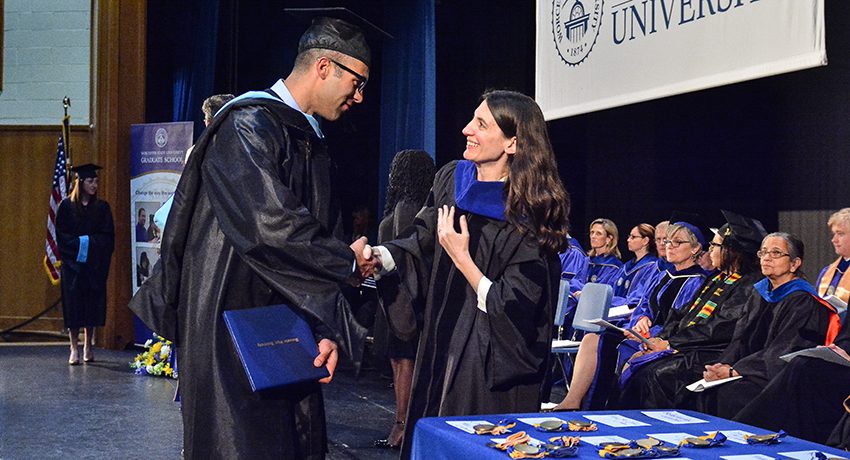 A Worcester State student receiving their diploma