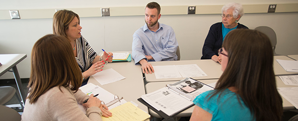 A group of ̳ State students and faculty discussing topics at a table