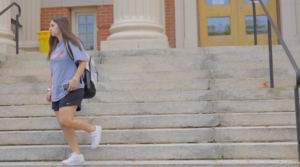A Worcester State student walking down stairs of a building on campus