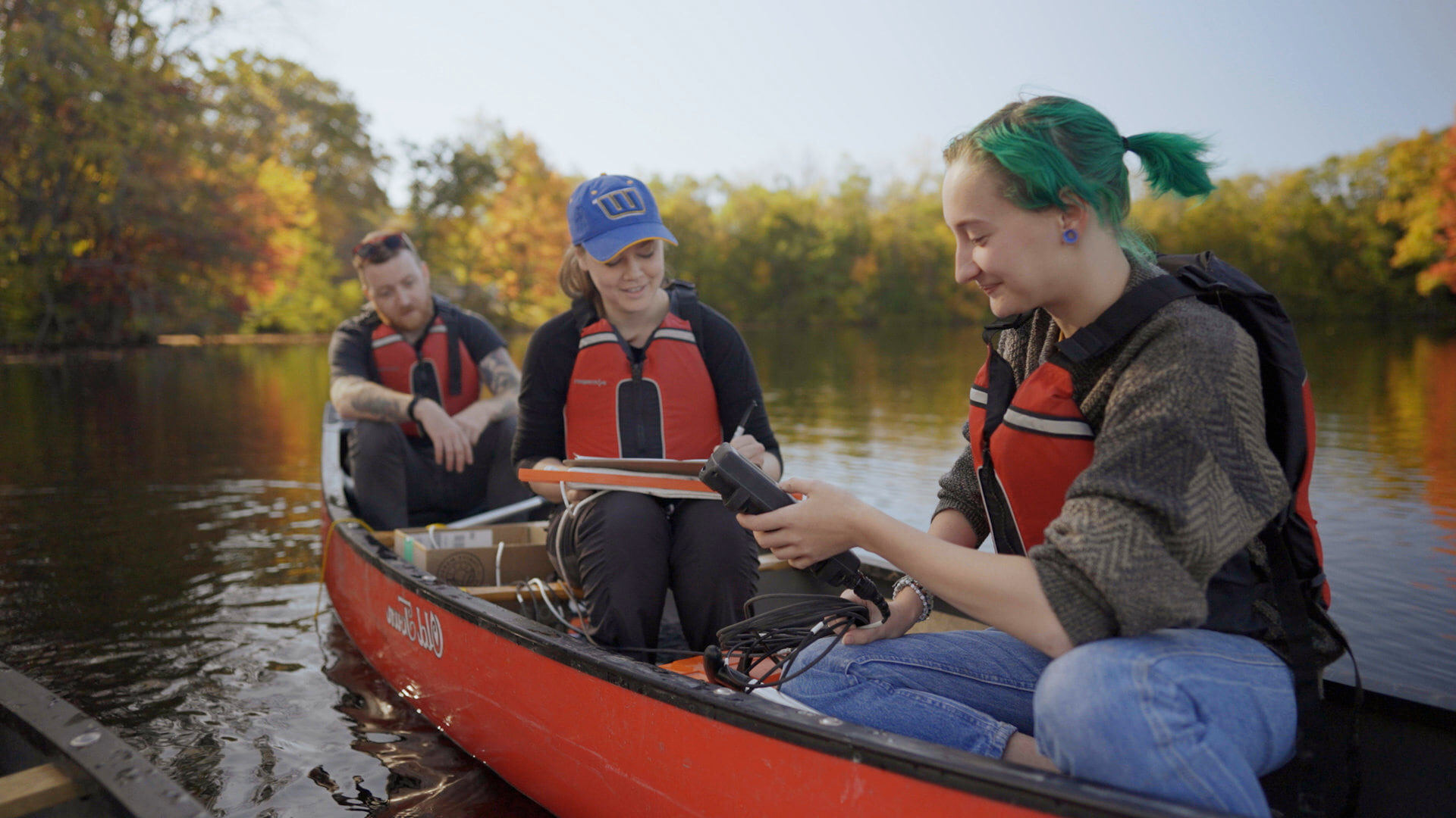 Worcester State students researching in a boat on a lake