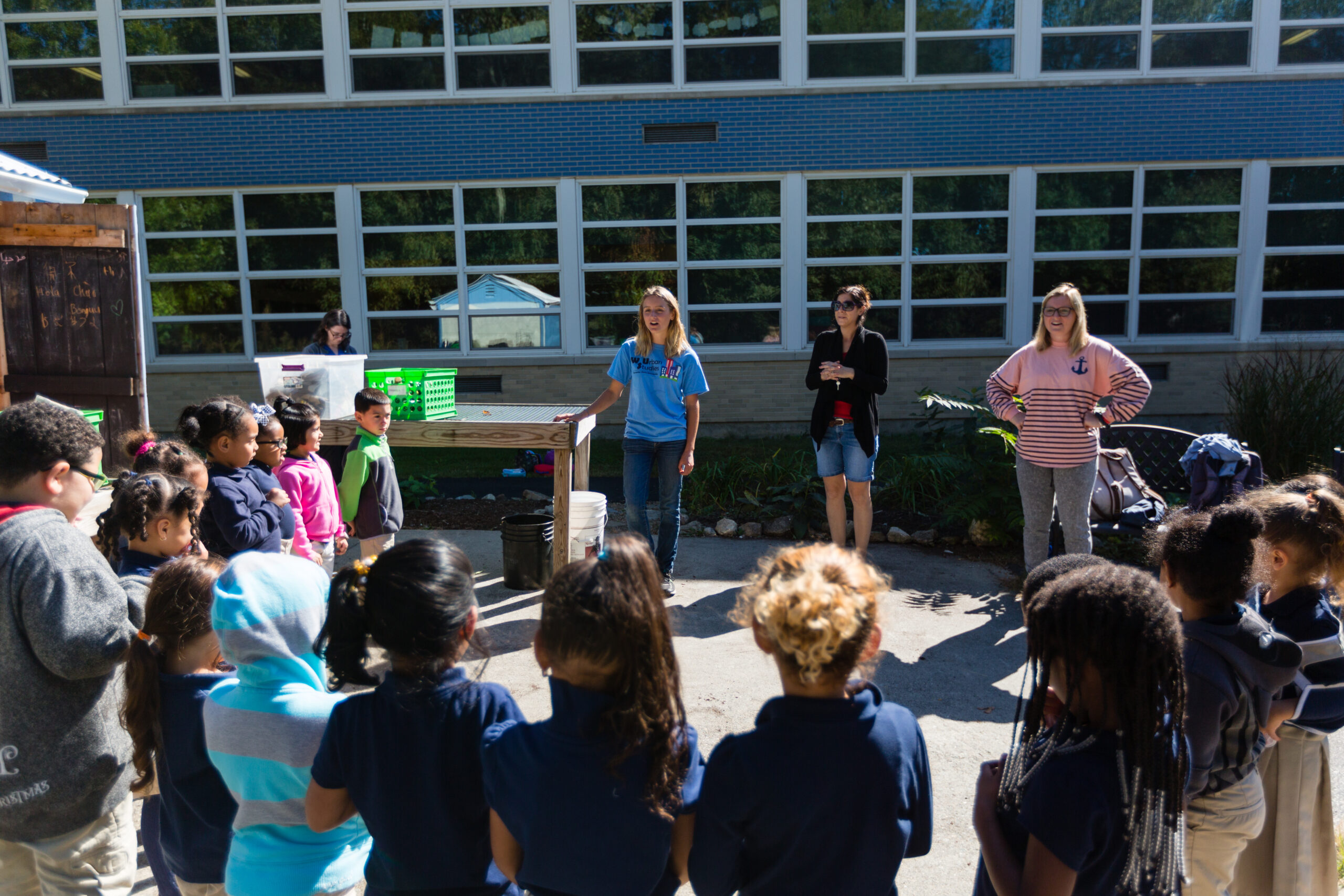 Worcester state students talking to a group of small school children