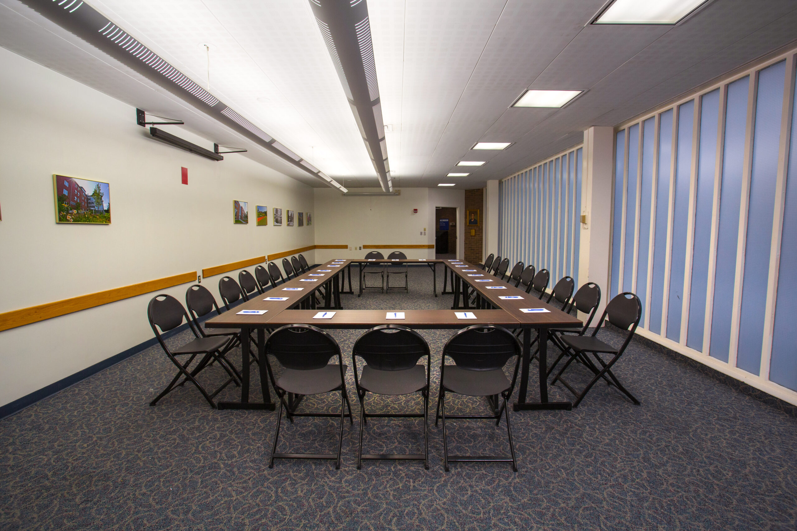 An empty Worcester State conference room with tables and chairs