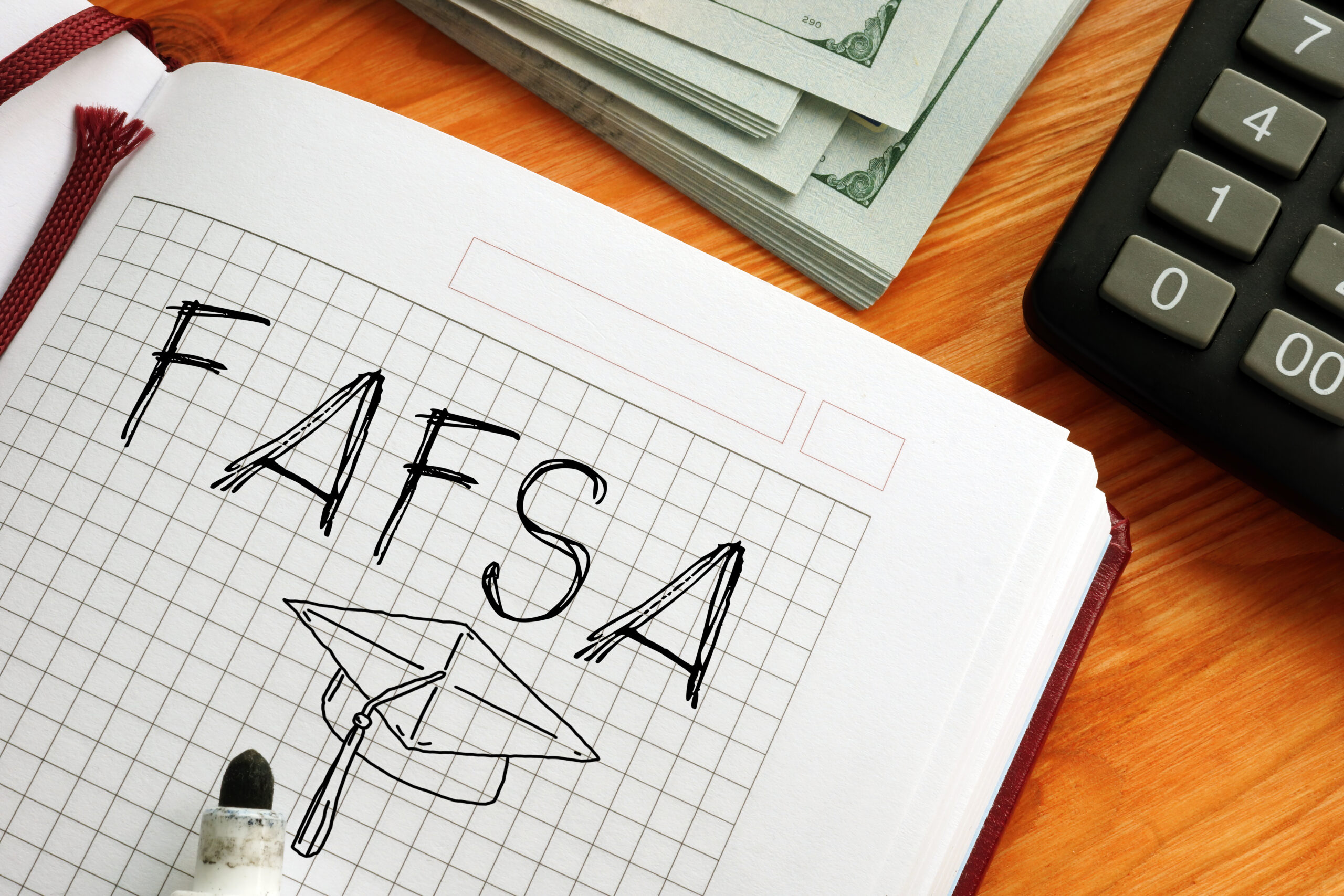 A notebook with the acronym FAFSA written in it in black marker
