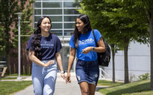 Two Worcester state students laughing as they walk through campus