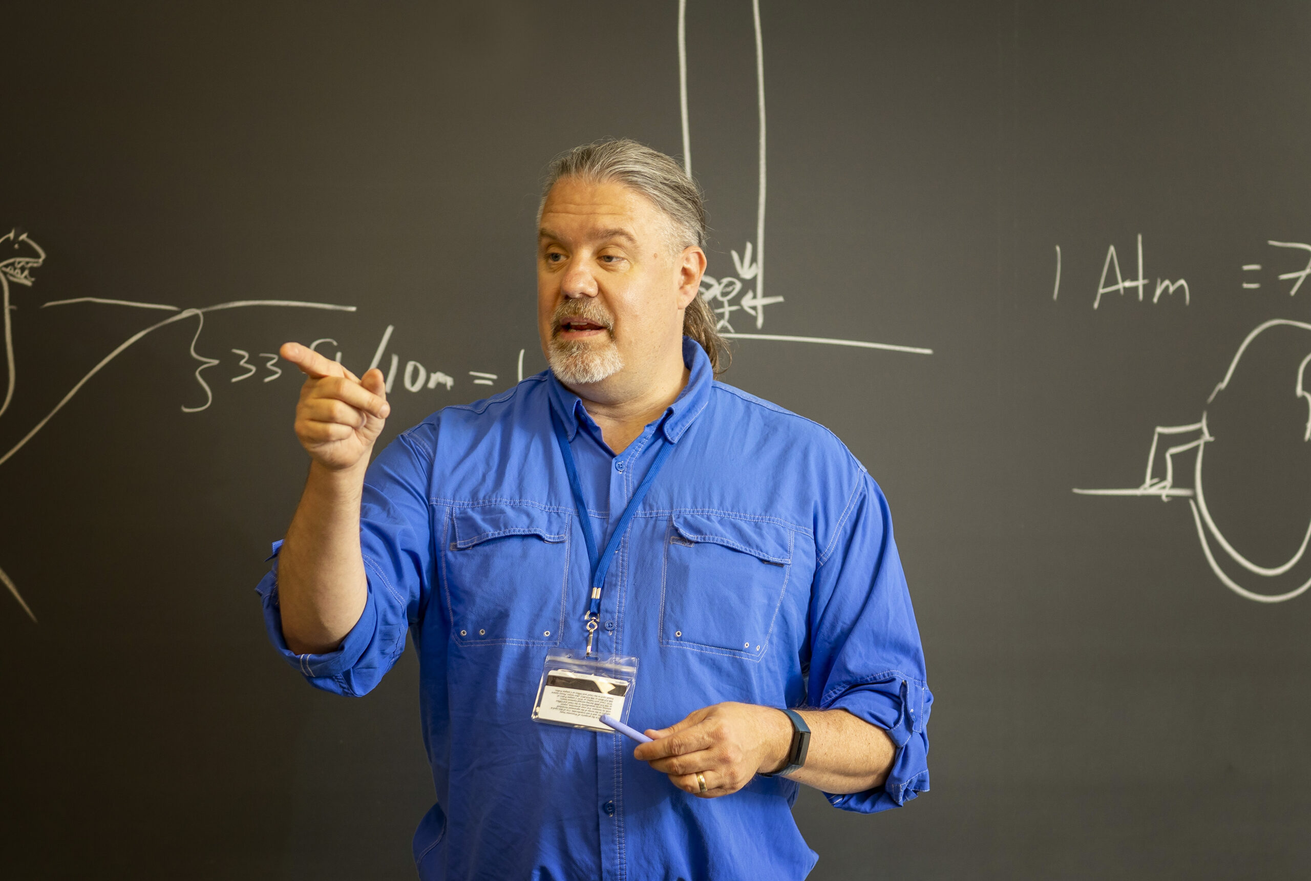 A Worcester state professor teaching with the assistance of a chalk board
