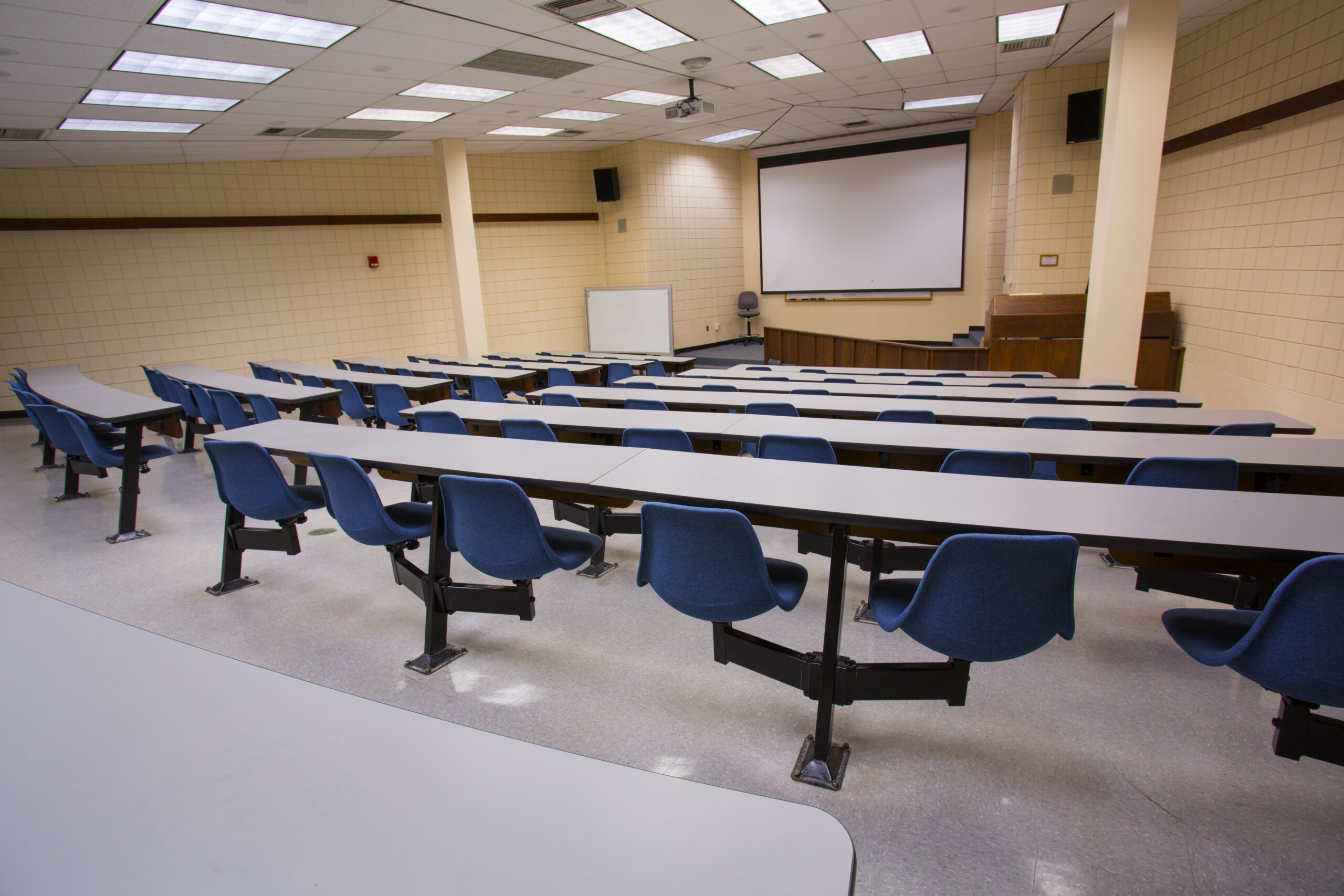 An empty Worcester State lecture hall with desks and chairs