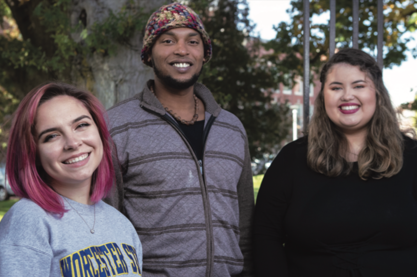 Three Worcester State students smiling for a photo on campus