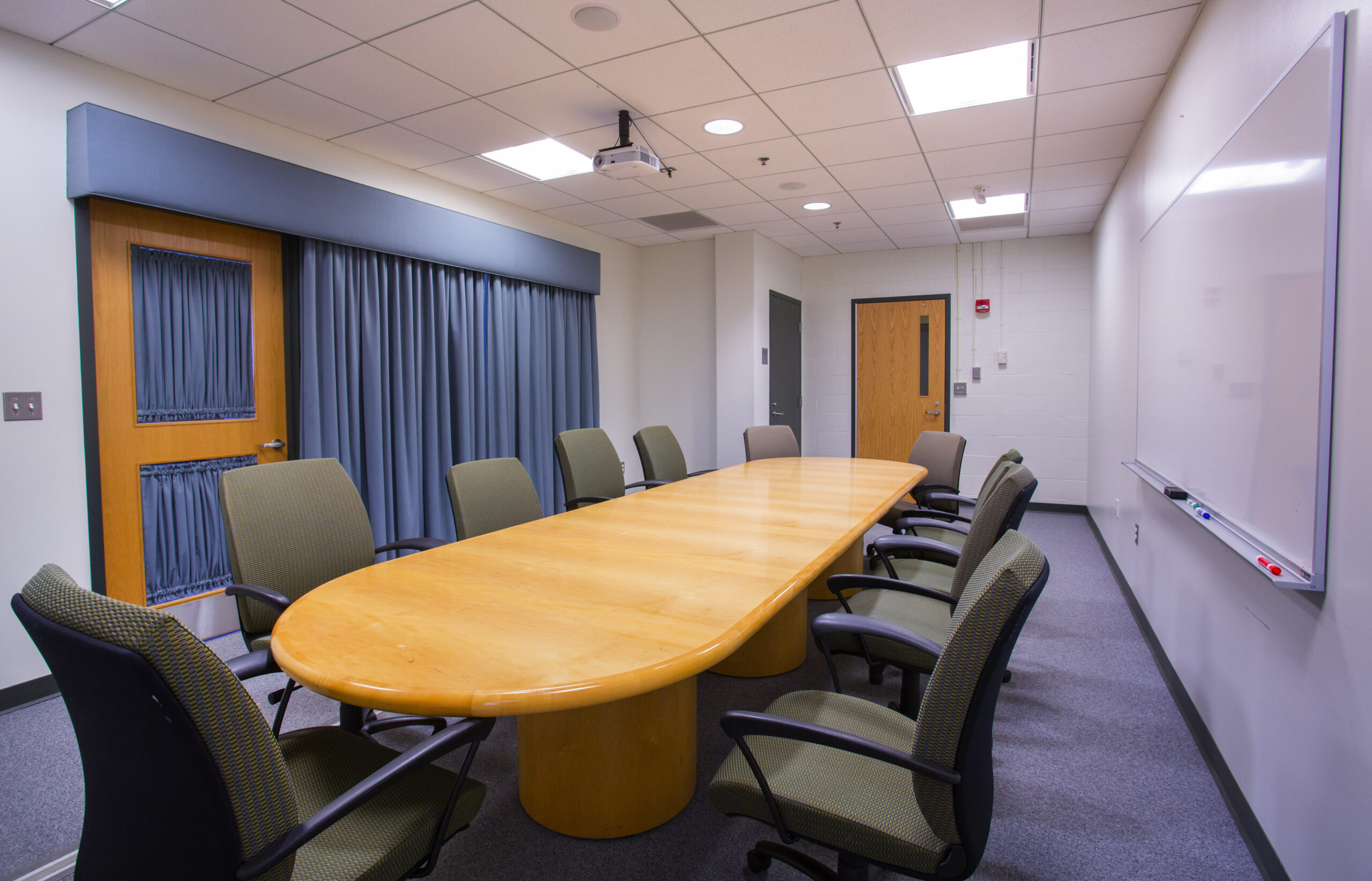 An empty Worcester State conference room with a circular table and chairs