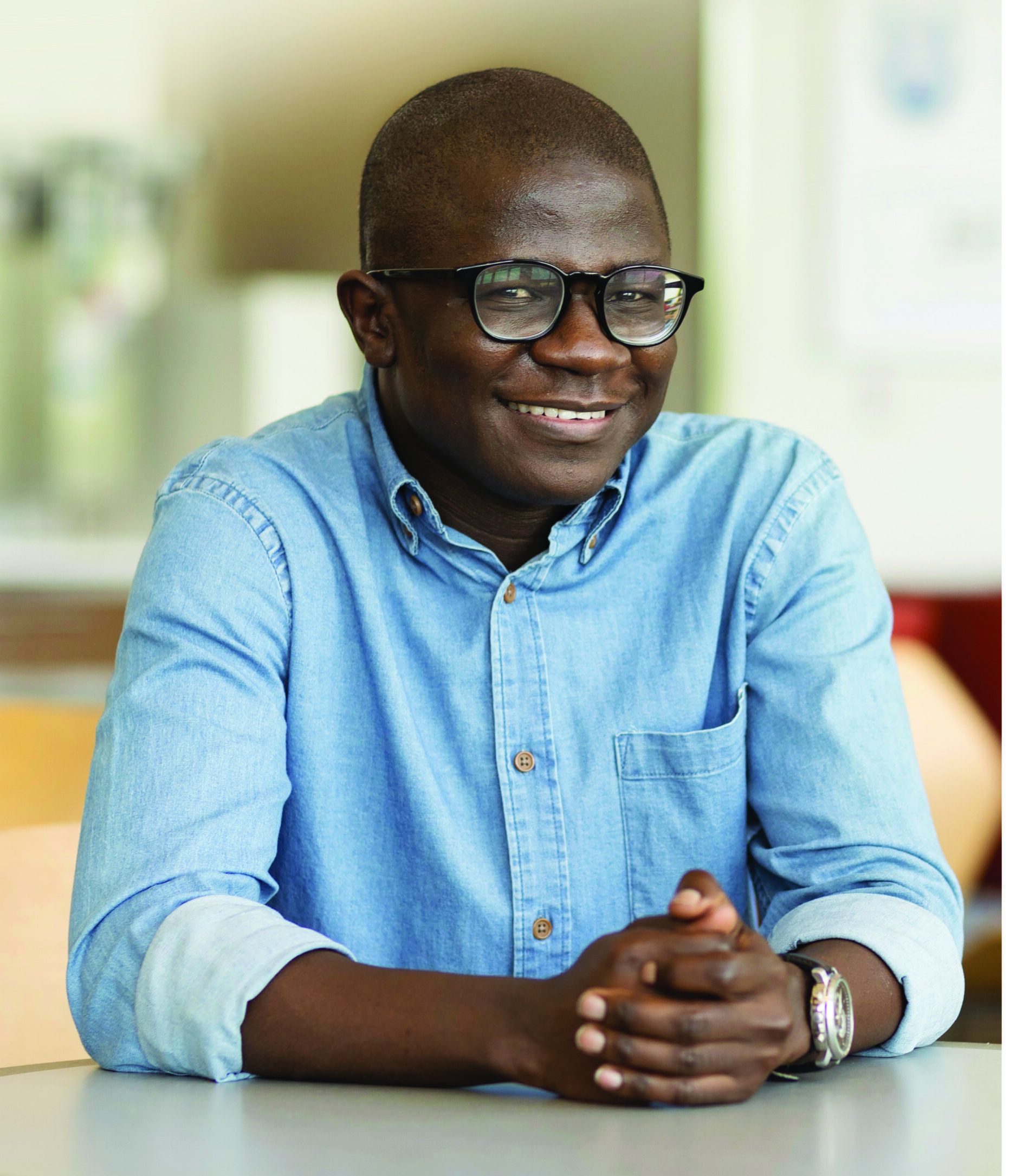 A smiling Worcester state student sitting at a table
