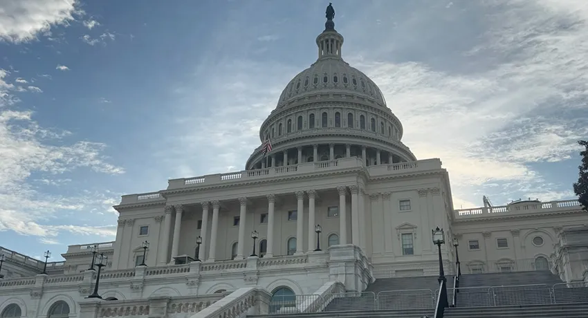 The United States Capitol building under a partly cloudy sky, viewed from the steps looking upward toward the dome, evokes a sense of inspiration much like Worcester State University’s iconic campus landmarks.