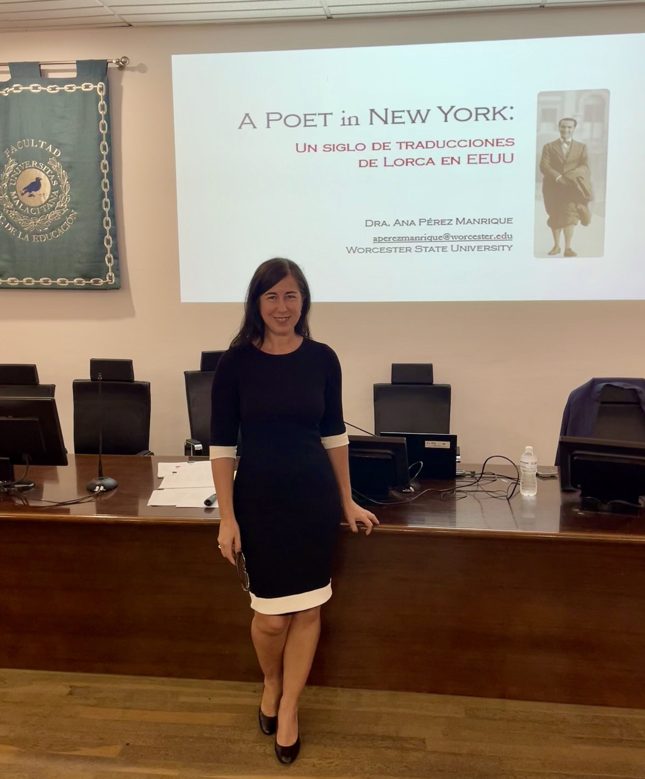 A woman stands in front of a presentation screen titled “A Poet in New York: Un Siglo de Traducciones de Lorca en EEUU” in a classroom or lecture hall.