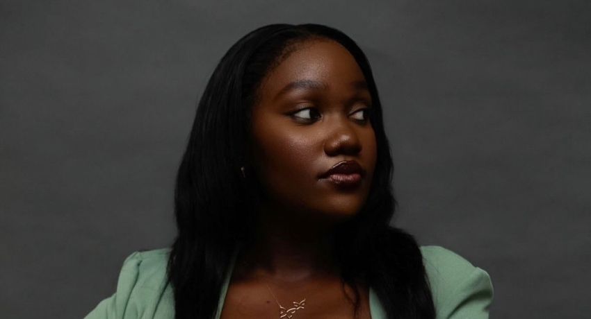 A Worcester State University woman looking toward the right side of the frame against a gray background.